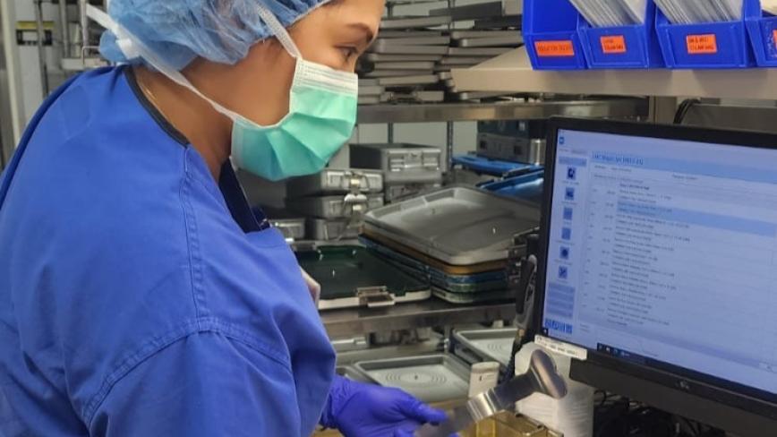 image of health care professional in PPE working to sterilize equipment