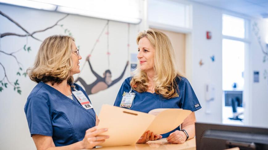 Two UC health professionals talking in a hospital setting