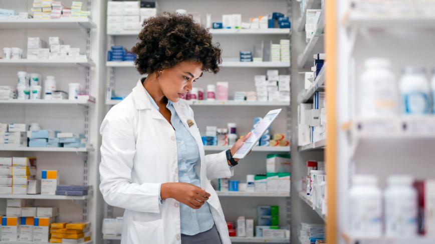 pharmacist in a white coat looking down at medications