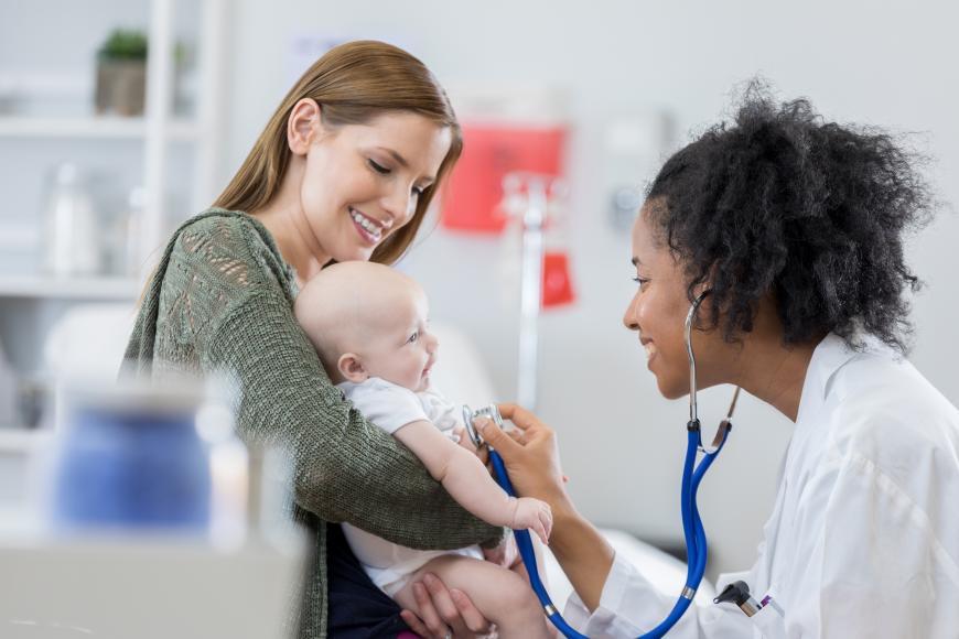 Person holding a baby with health care provider