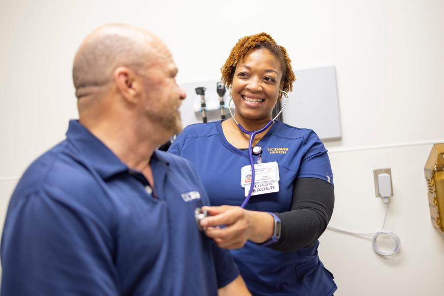 UC health care professional holding stethoscope with patient